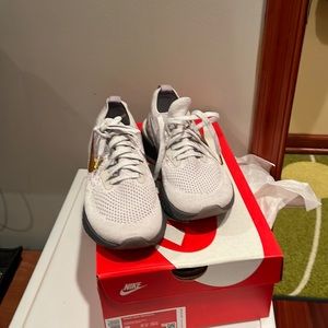 Nike sneakers with gold and white Nike symbols